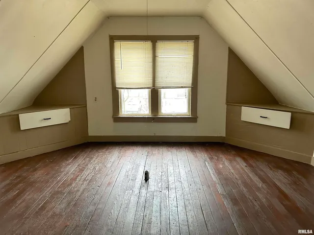 a view of a room with wooden floor and windows