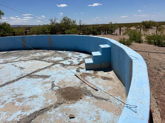 a blue umbrella sitting in the middle of a backyard