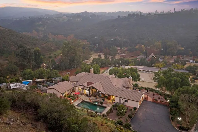 a view of residential houses with yard and mountain view in back