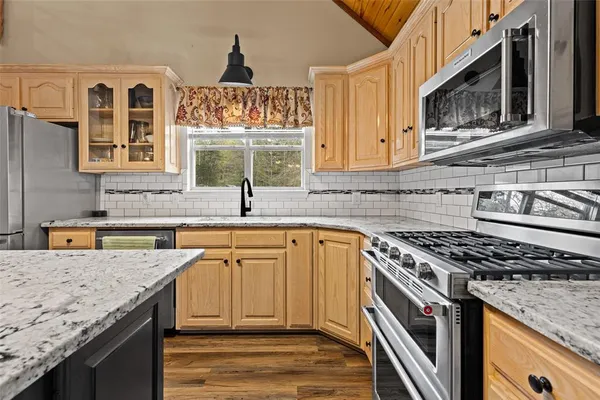 a kitchen with stainless steel appliances granite countertop a sink stove and cabinets