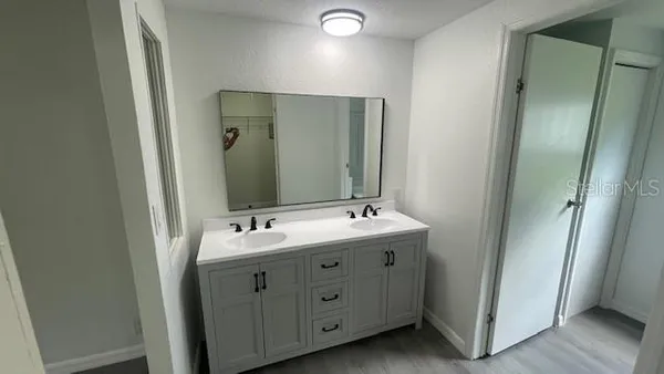 a spacious bathroom with a double vanity sink and mirror