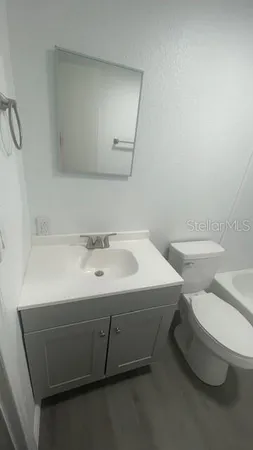 a bathroom with a sink toilet and mirror