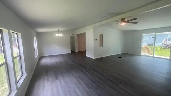 an empty room with wooden floor and entrance