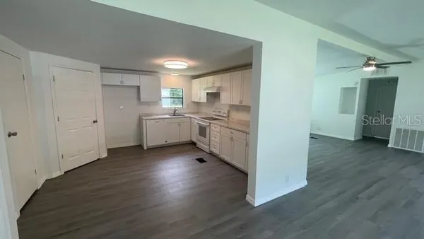 a kitchen with cabinets and wooden floor