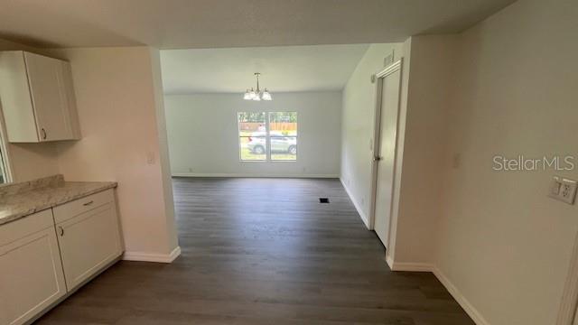 8897 Southwest 34th Court Ocala, FL 34476 - Photo 10 of 18 a view of an empty room with wooden floor and a window