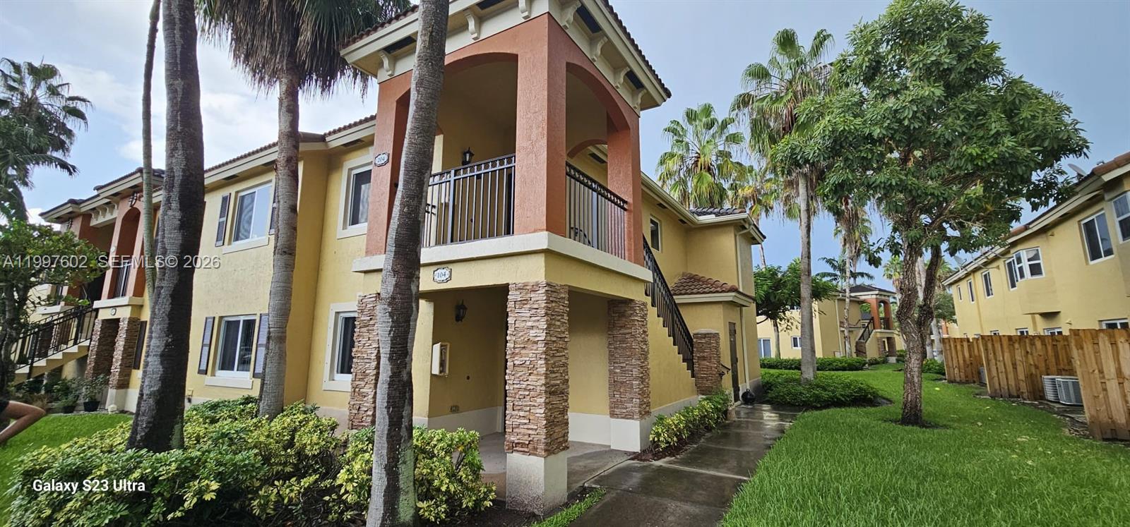 a front view of a multi story residential apartment building with a yard