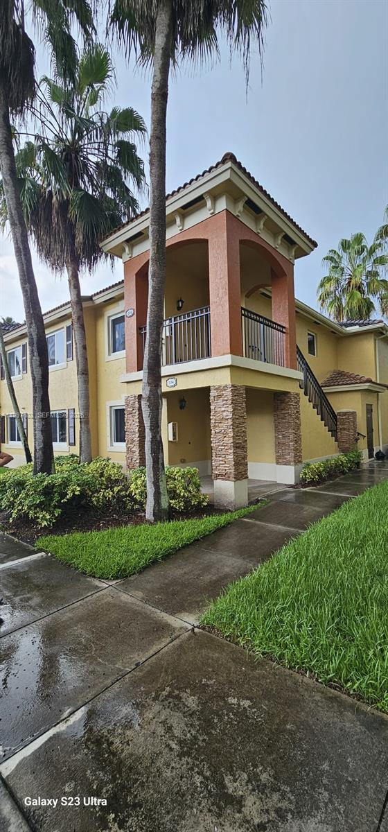 935 Northeast 33rd Terrace, Unit 204 Homestead, FL 33033 - Photo 14 of 28 a front view of a house with a garden