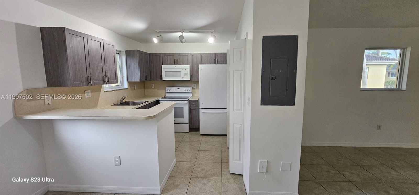935 Northeast 33rd Terrace, Unit 204 Homestead, FL 33033 - Photo 20 of 28 a kitchen with stainless steel appliances a refrigerator and a stove top oven