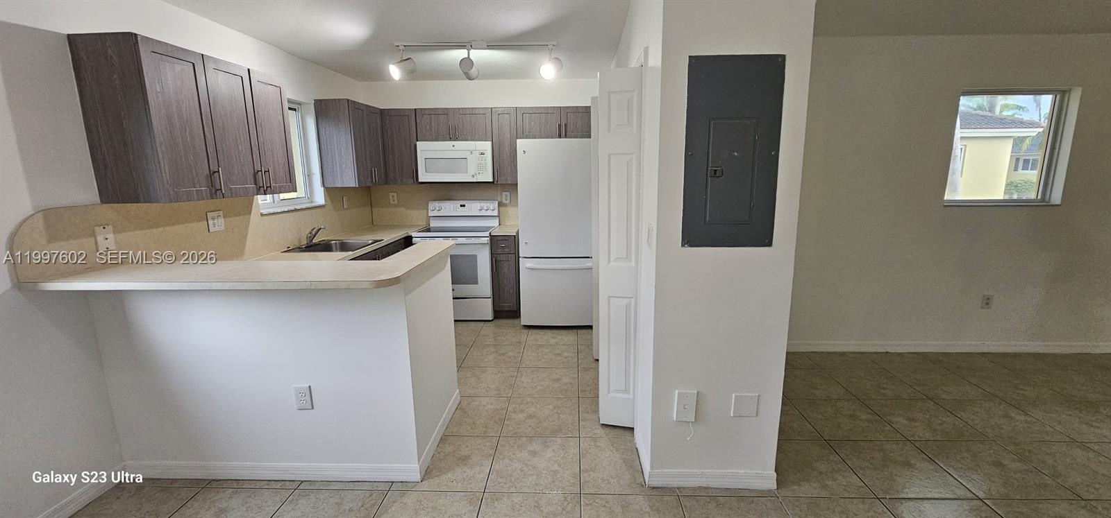 935 Northeast 33rd Terrace, Unit 204 Homestead, FL 33033 - Photo 21 of 28 a kitchen with a sink cabinets and appliances