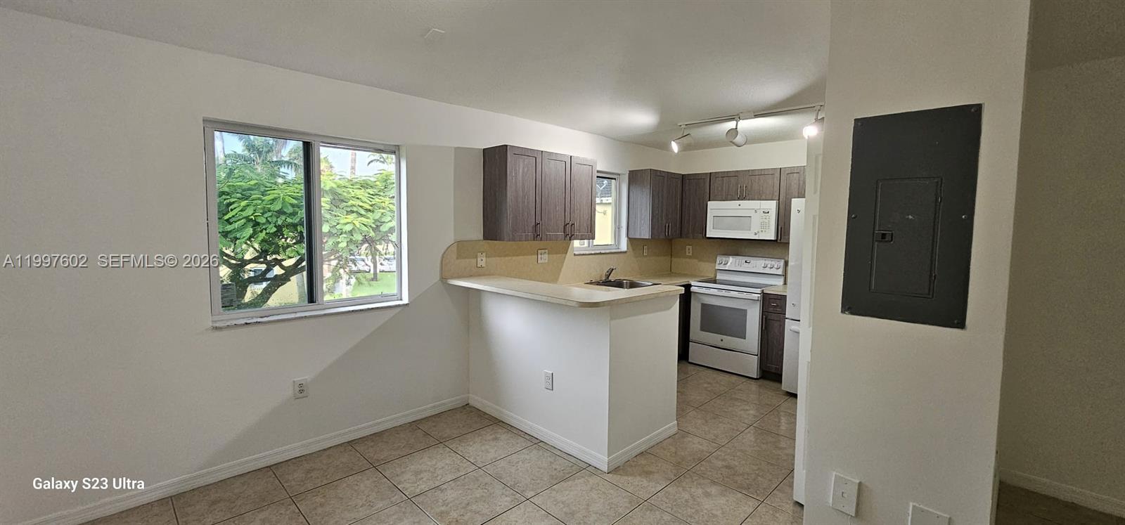 935 Northeast 33rd Terrace, Unit 204 Homestead, FL 33033 - Photo 22 of 28 a kitchen with stainless steel appliances granite countertop a refrigerator sink and stove