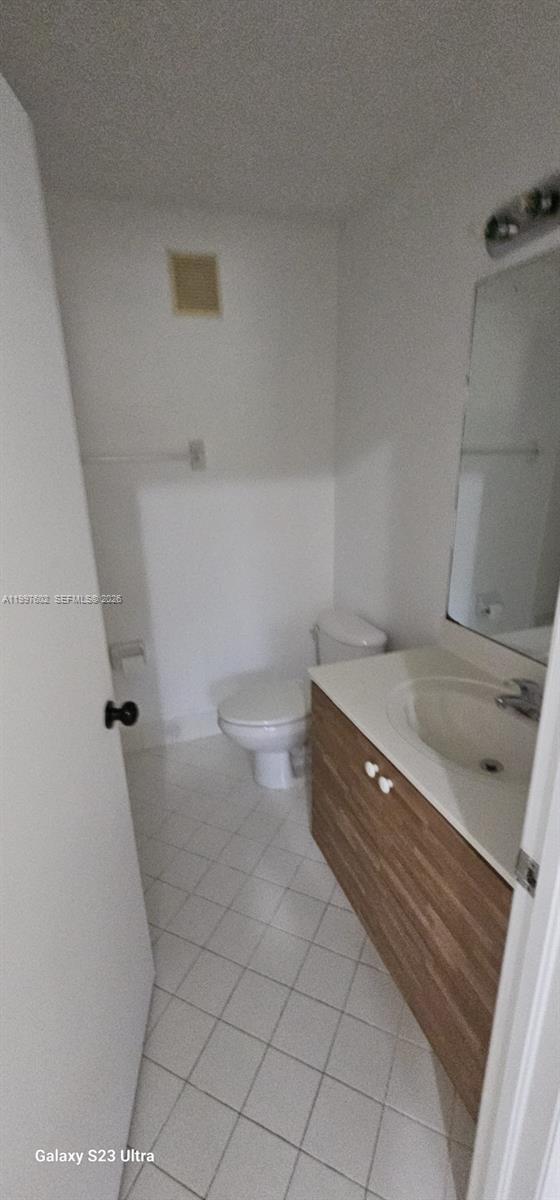 935 Northeast 33rd Terrace, Unit 204 Homestead, FL 33033 - Photo 25 of 28 a bathroom with a sink a toilet and a mirror