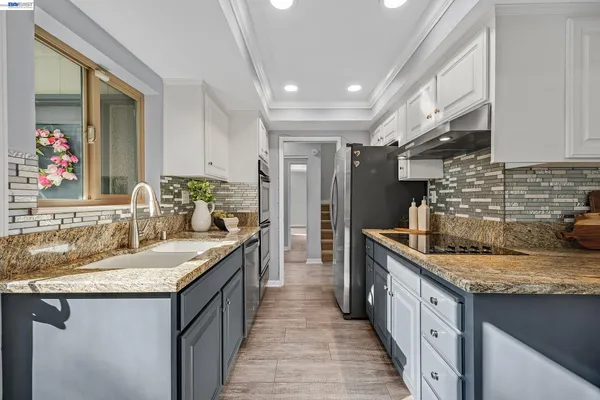 a view of a big house with a big yard and potted plants and large trees