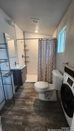 a white toilet sitting next to a bathroom sink and tub