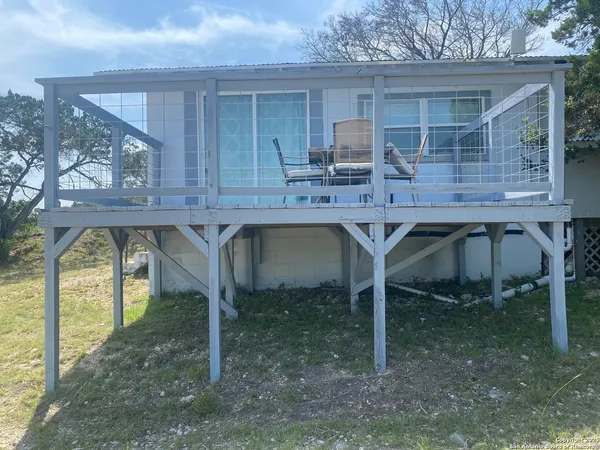 a table and chairs sitting in a backyard room next to a yard