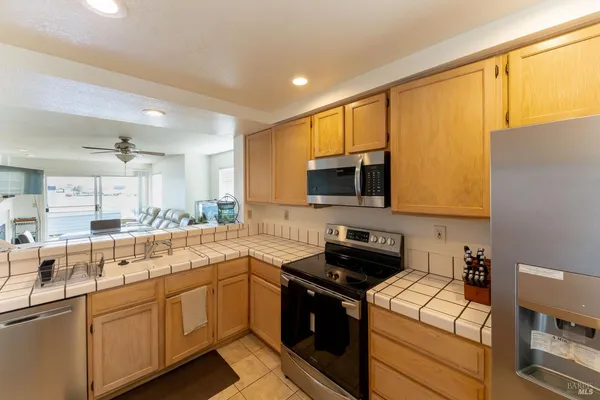 a kitchen with stainless steel appliances a sink a stove a microwave and cabinets