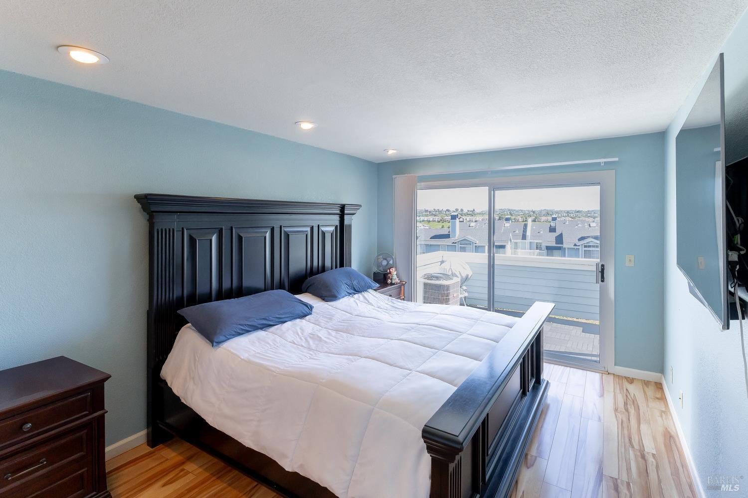 911 Point Reyes Court, Unit 6 Vallejo, CA 94591 - Photo 10 of 35 a bedroom with a bed and a dresser with wooden floor
