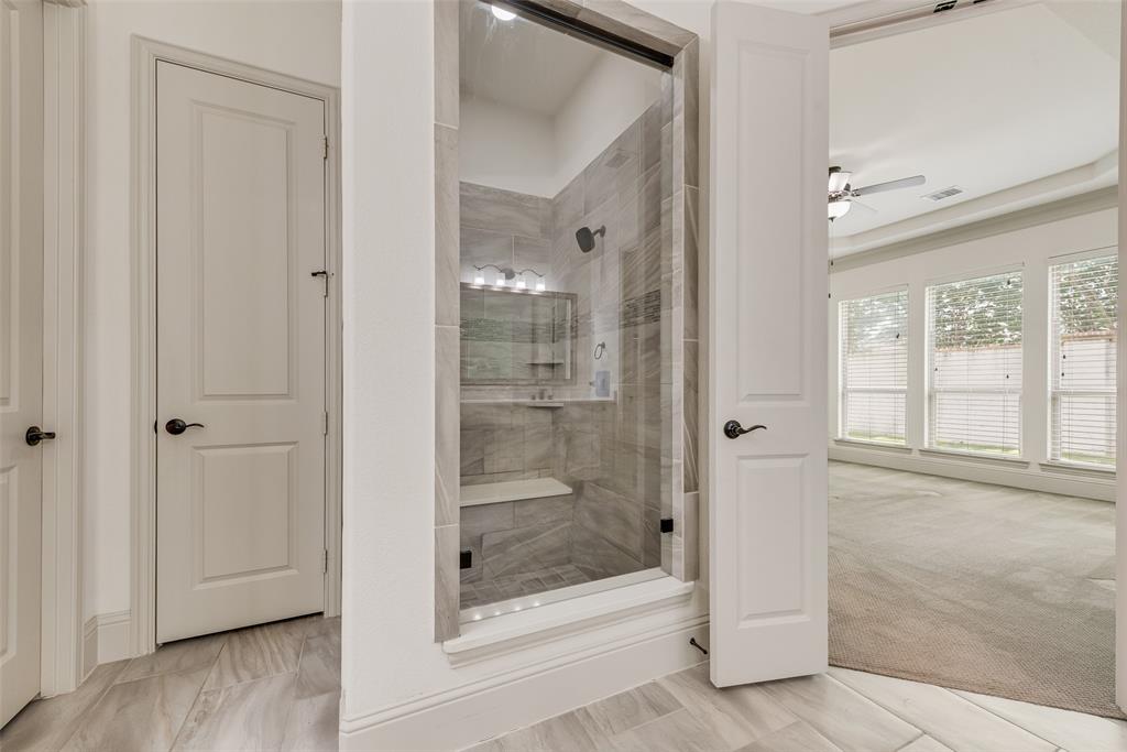 2021 Calisto Way Allen, TX 75013 - Photo 22 of 34 Contemporary glass-enclosed shower with a built-in bench and tiled walls