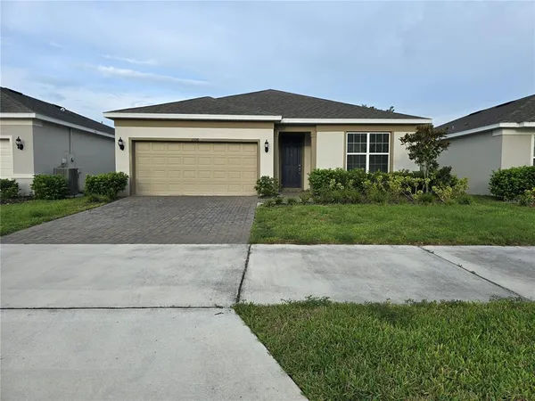 a front view of a house with a yard and a garage