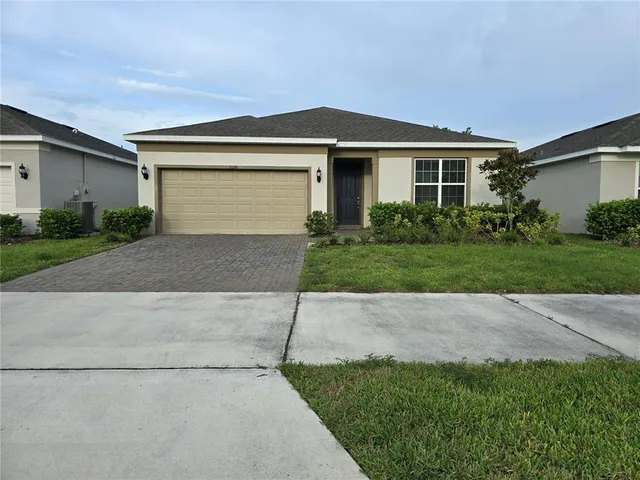 a front view of a house with a yard and a garage