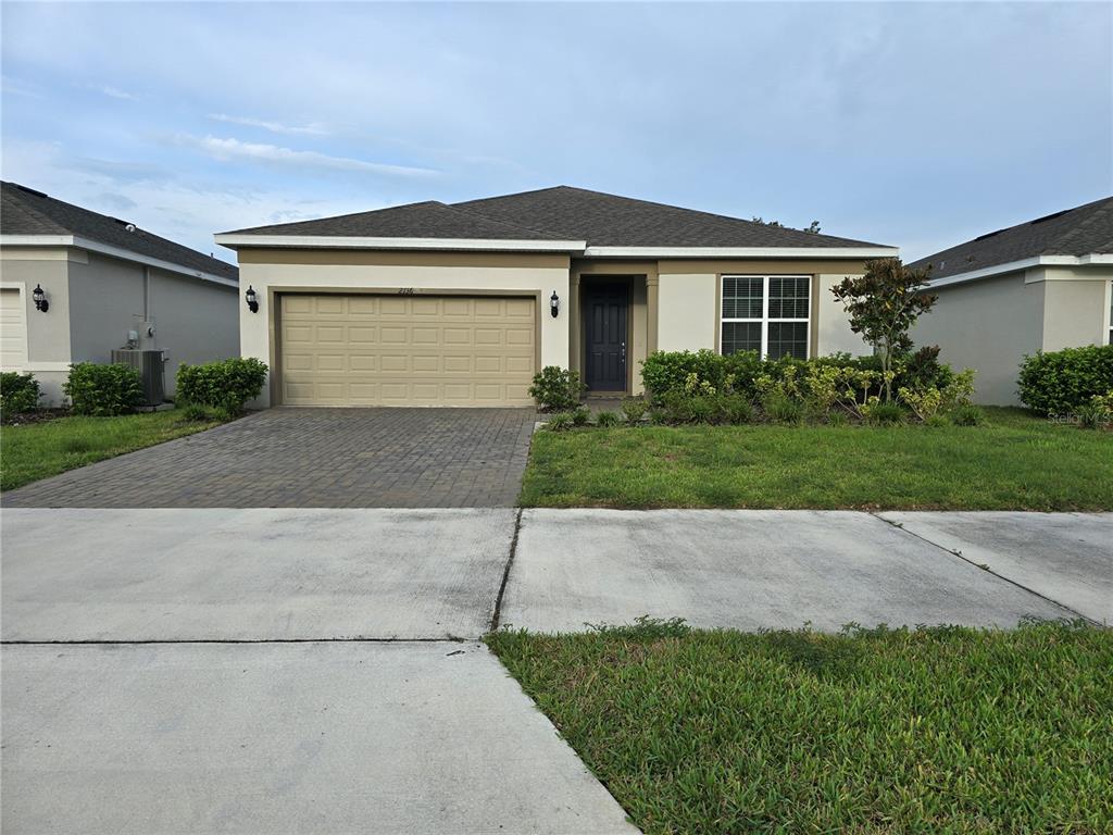 a front view of a house with a yard and a garage