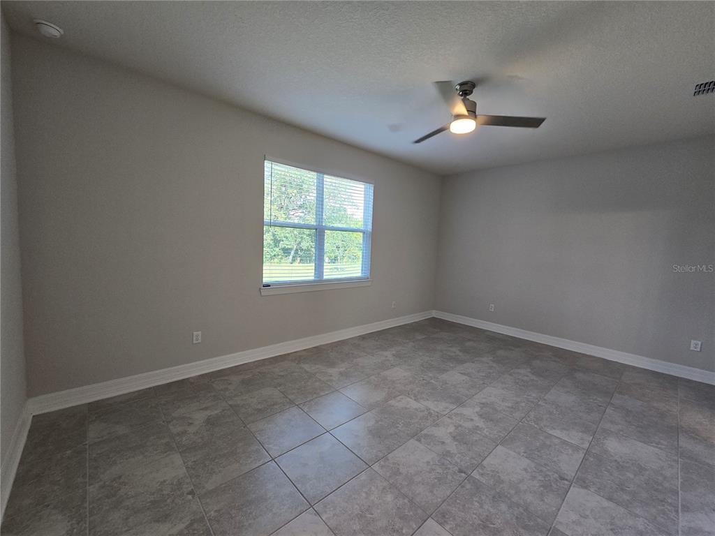 2136 Live Oak Lake Road St. Cloud, FL 34771 - Photo 14 of 42 an empty room with windows and chandelier fan