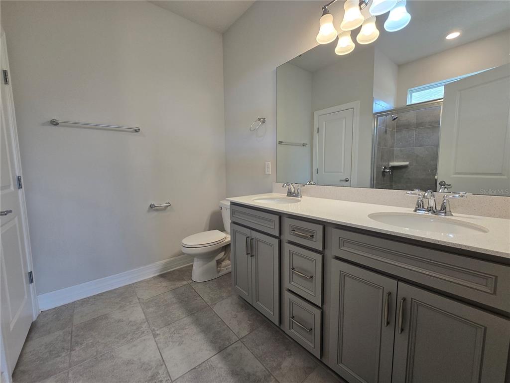 2136 Live Oak Lake Road St. Cloud, FL 34771 - Photo 17 of 42 a bathroom with a granite countertop sink a toilet and a mirror