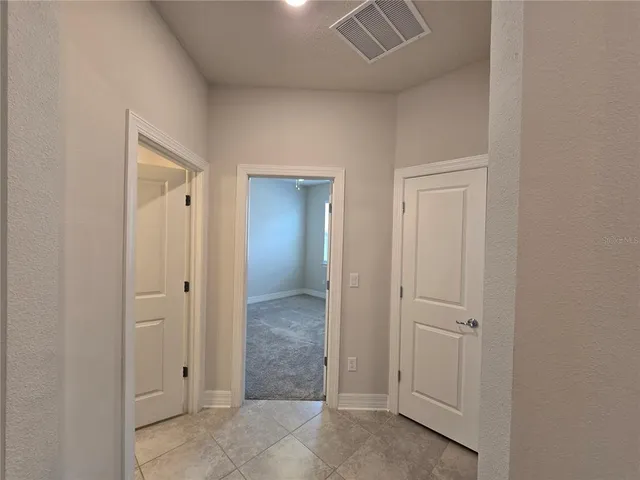 an empty room with mirror and a bathroom
