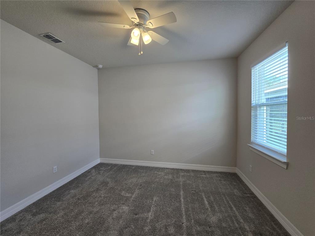 2136 Live Oak Lake Road St. Cloud, FL 34771 - Photo 25 of 42 an empty room with a window and a fan