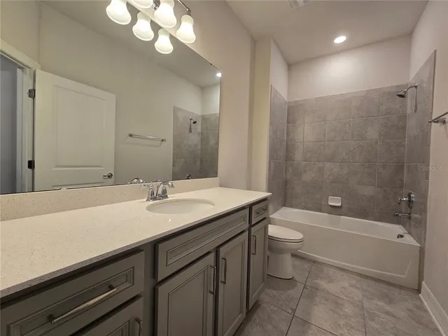 a bathroom with a granite countertop sink a toilet a mirror and shower