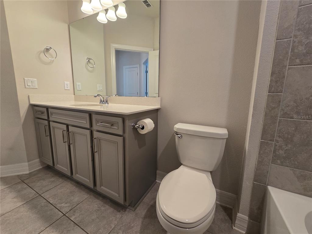 2136 Live Oak Lake Road St. Cloud, FL 34771 - Photo 29 of 42 a bathroom with a toilet a sink and mirror