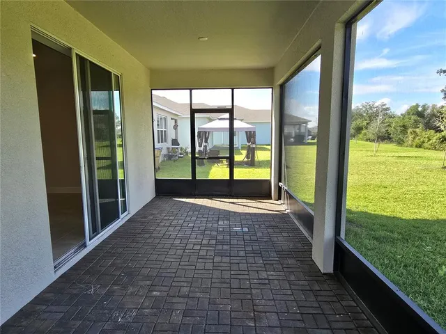 a view of empty room with floor to ceiling windows with yard