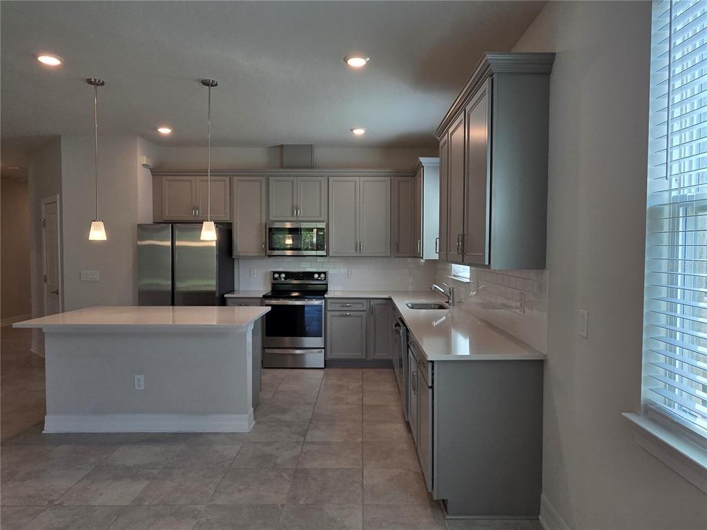 2136 Live Oak Lake Road St. Cloud, FL 34771 - Photo 7 of 42 a kitchen with stainless steel appliances granite countertop a sink stove and refrigerator
