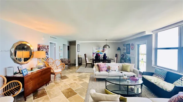 a living room with furniture a table and a large window