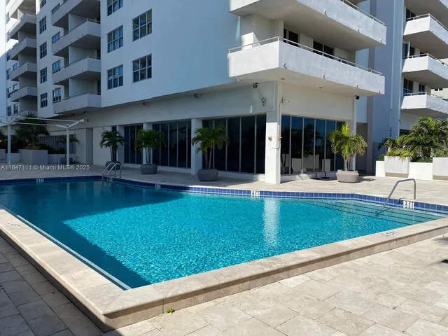 a view of a big building with a big yard and plants