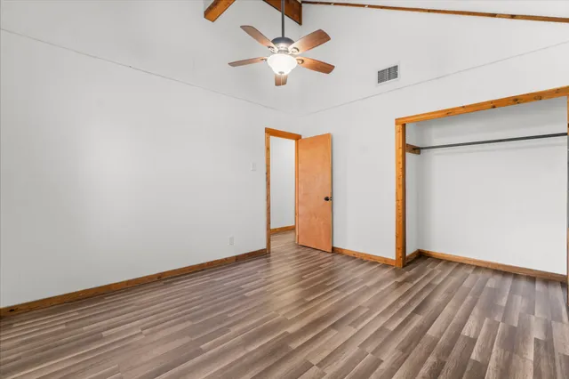 a view of an empty room with wooden floor