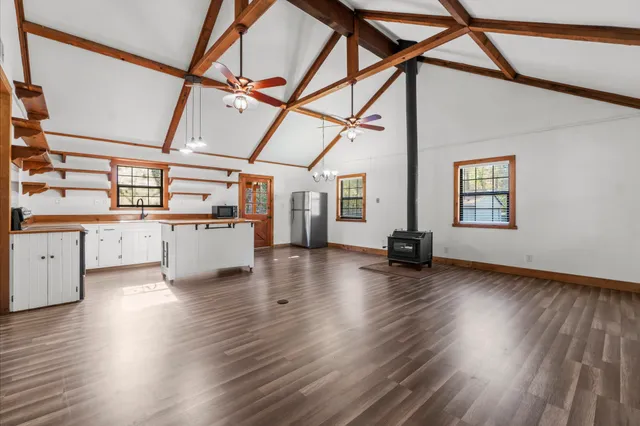 a view of a kitchen with wooden floors and black appliances