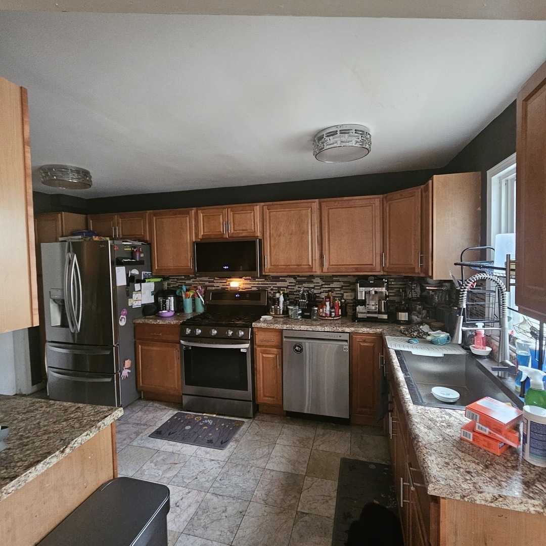 128 Essex Road Elk Grove Village, IL 60007 - Photo 5 of 18 a kitchen with stainless steel appliances granite countertop a stove sink and refrigerator