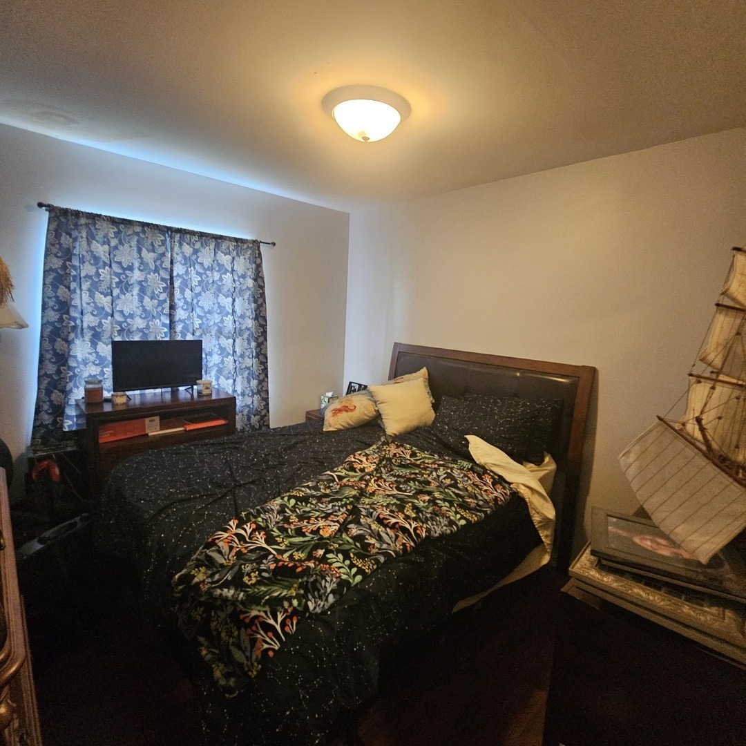 128 Essex Road Elk Grove Village, IL 60007 - Photo 10 of 18 a bed sitting in a room next to a lamp with a fireplace