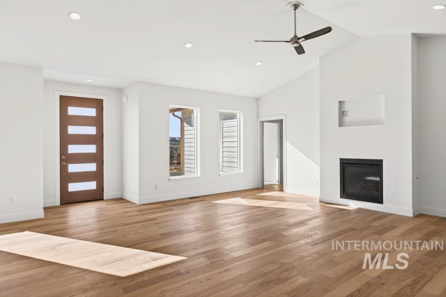780 Victoria Drive Moscow, ID 83843 - Photo 14 of 44 Unfurnished living room featuring a glass covered fireplace, light wood-type flooring, ceiling fan, recessed lighting, and lofted ceiling