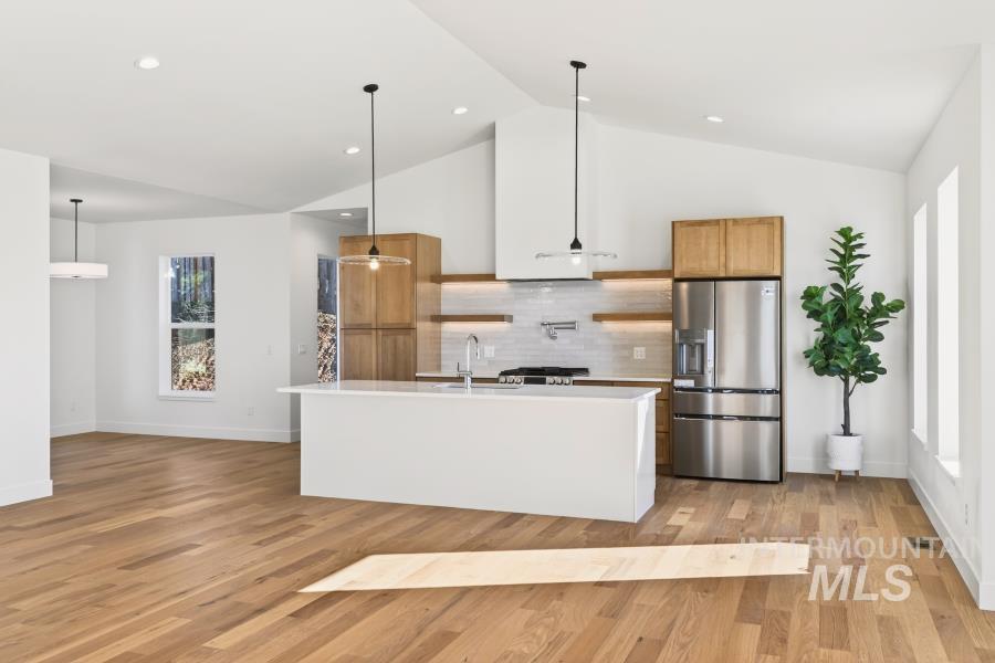 780 Victoria Drive Moscow, ID 83843 - Photo 16 of 44 Kitchen with stainless steel appliances, wood finish cabinetry, a center island with sink, light wood finished floors, and pendant lighting