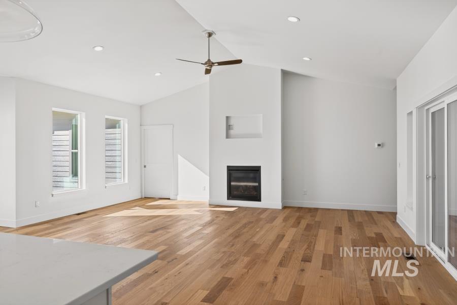 780 Victoria Drive Moscow, ID 83843 - Photo 18 of 44 Unfurnished living room featuring light wood finished floors, a glass covered fireplace, ceiling fan, a high ceiling, and recessed lighting
