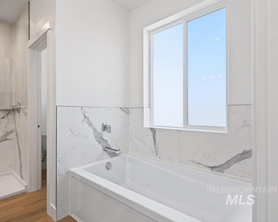 780 Victoria Drive Moscow, ID 83843 - Photo 26 of 44 Full bath featuring a garden tub, light wood finished floors, and wainscoting