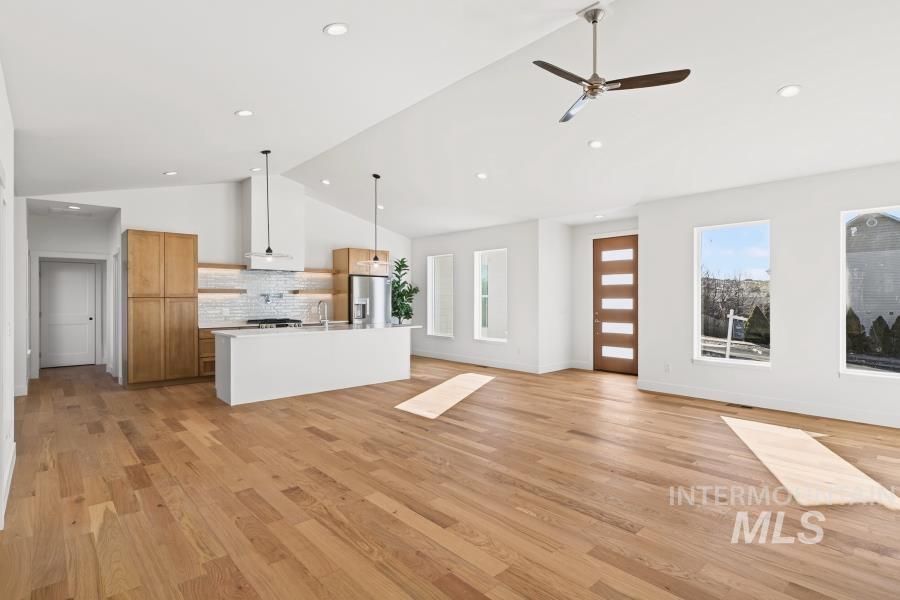 780 Victoria Drive Moscow, ID 83843 - Photo 5 of 44 Unfurnished living room featuring vaulted ceiling, ceiling fan, and light wood-type flooring