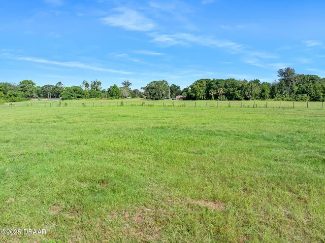 a view of a patio with a table and chairs under an umbrella