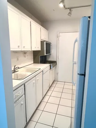 a kitchen with white cabinets and white appliances
