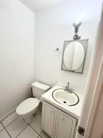 a bathroom with a toilet a sink and mirror