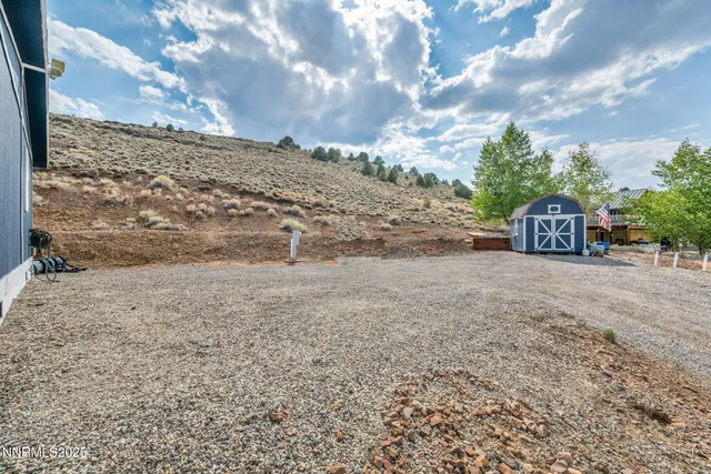 a view of a dry yard with wooden fence