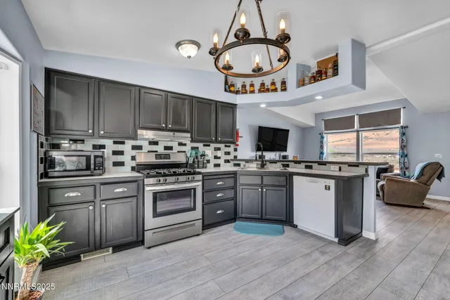 a kitchen with stainless steel appliances granite countertop a stove refrigerator and microwave
