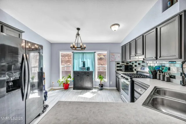 a kitchen with stainless steel appliances granite countertop a refrigerator and a stove