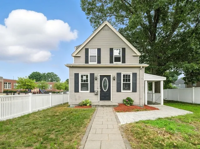 a front view of a house with a yard and potted plants